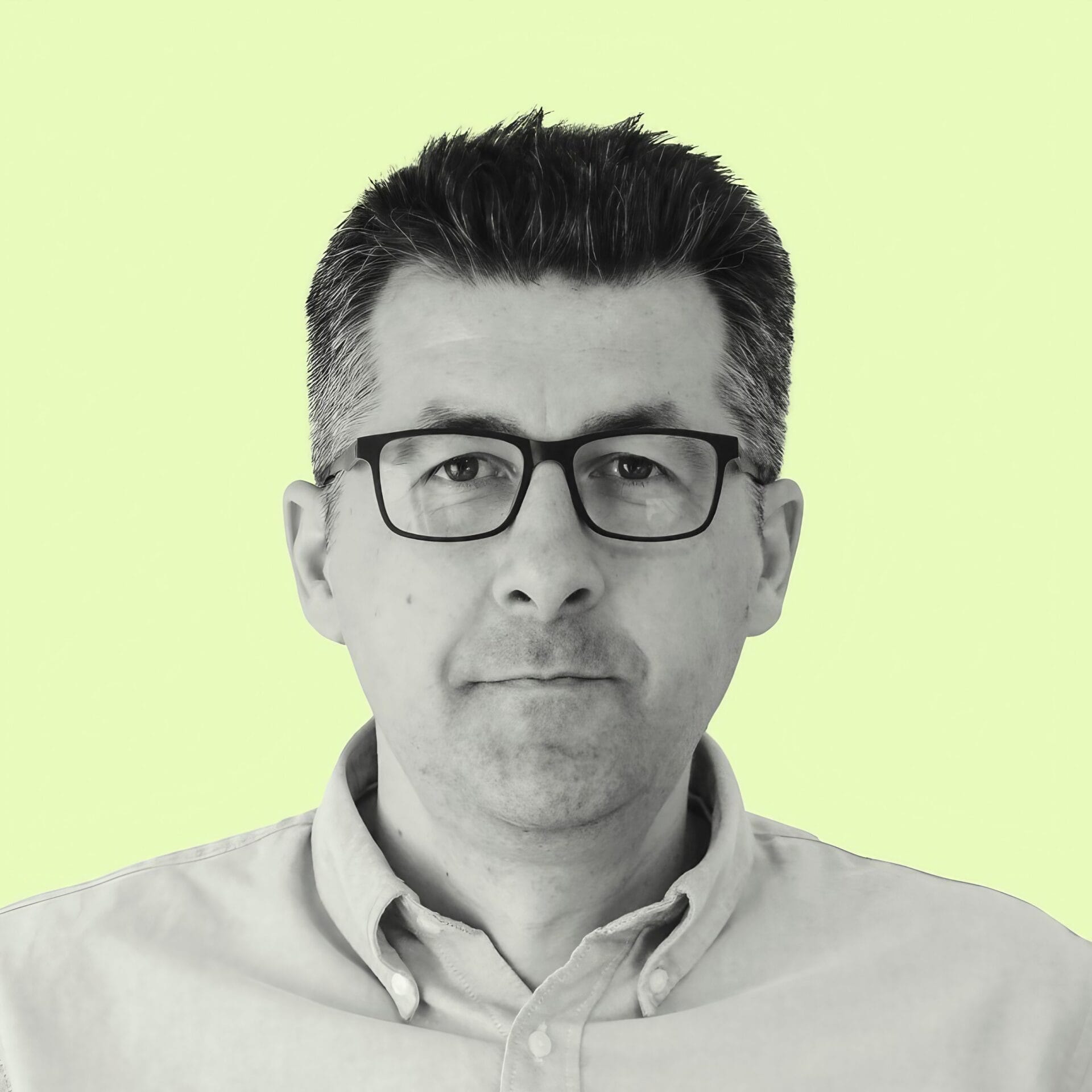 Man with glasses on yellow background.